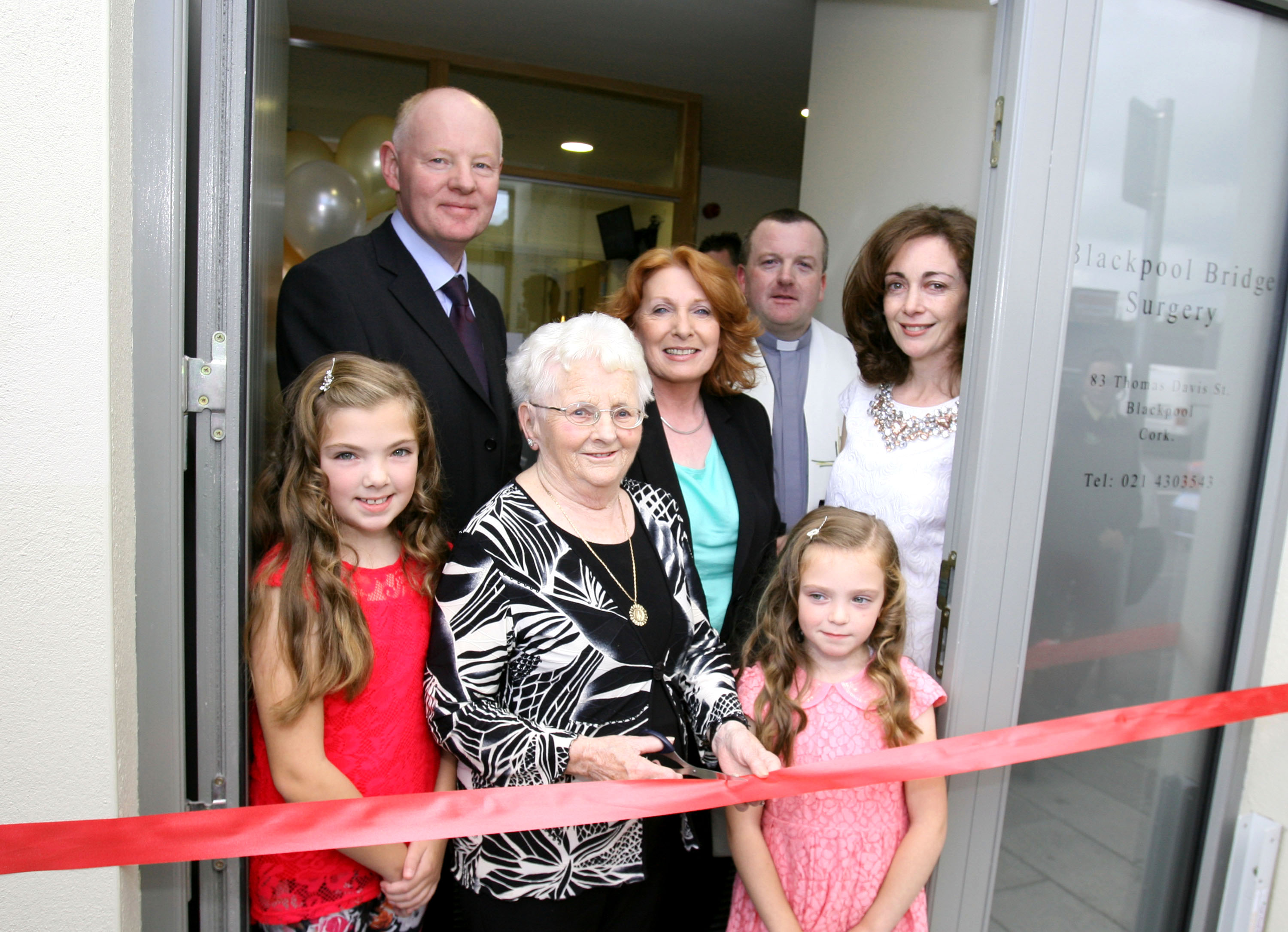 Cutting the tape to officially open the New Blackpool Bridge Surgery were, Long time Blackpool Native Peggy Manning ablely assisted by Chloe and Ciar Vaughan, also in Picture, Dr. John Sheehan, Minister Kathleen Lynch T.D..Fr. Damian O'Mahony and Dr. Antoinette Morission. Picture, Tony O'Connell Photography.